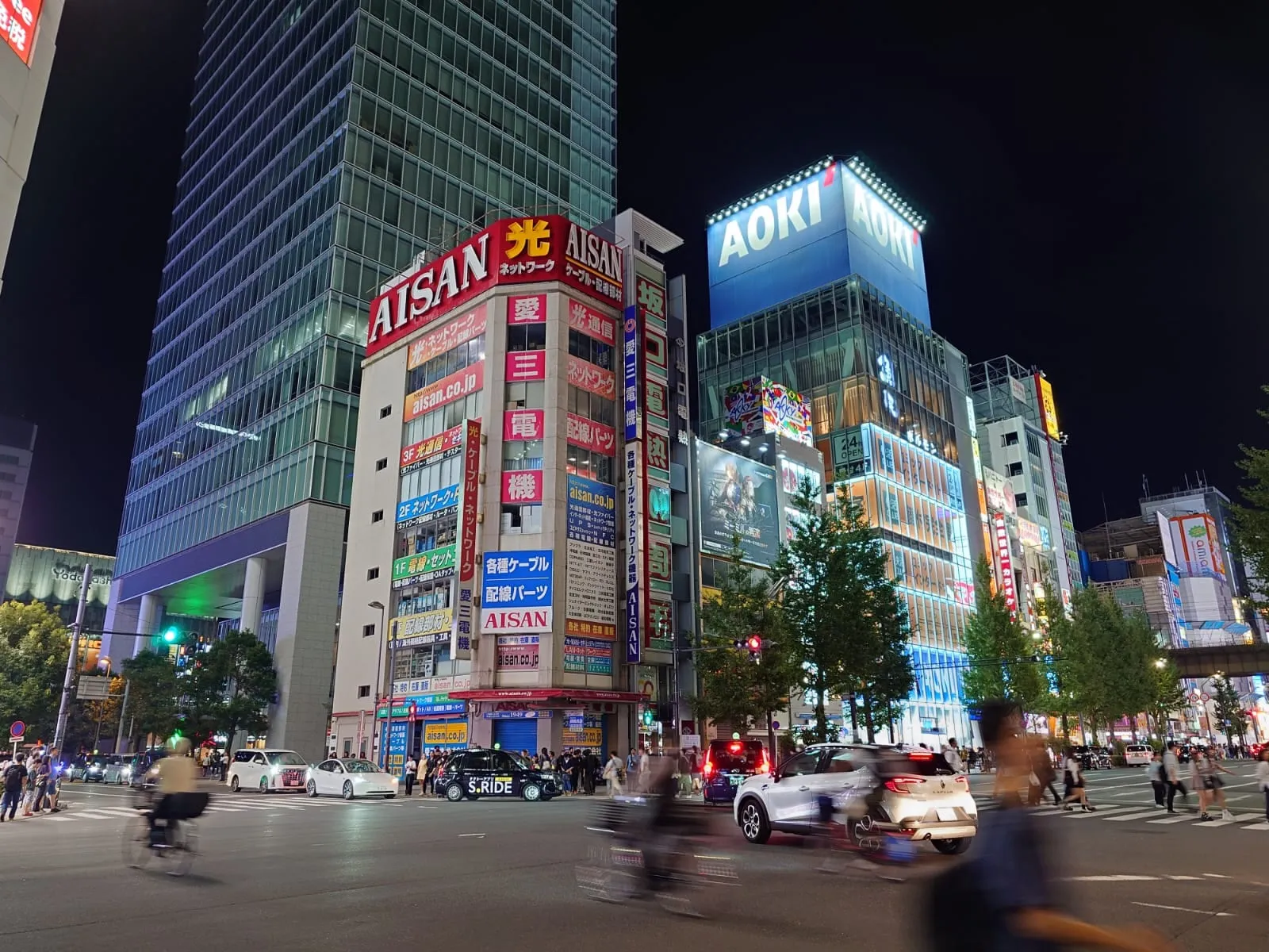 Incrocio di Akihabara di notte con palazzi pieni di insegne luminose