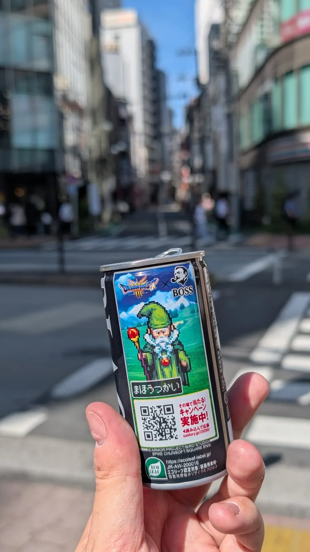 Mano che regge una lattina di caffè BOSS con un mago di Dragon Quest