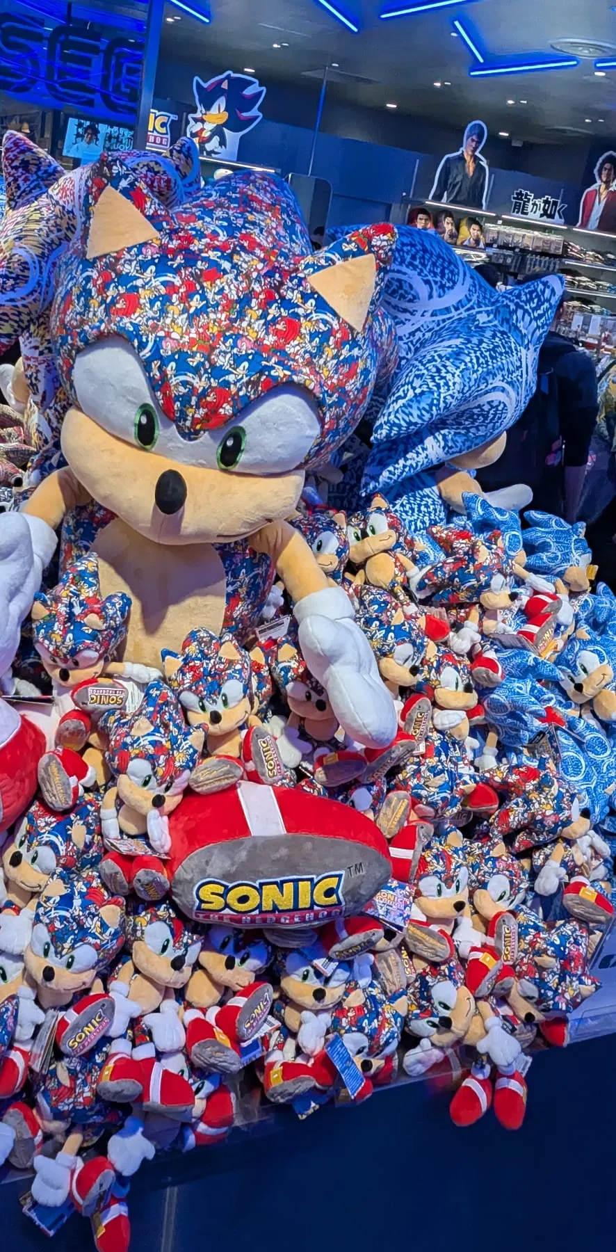 Montagna di peluche di Sonic in un negozio SEGA con luci blu al neon