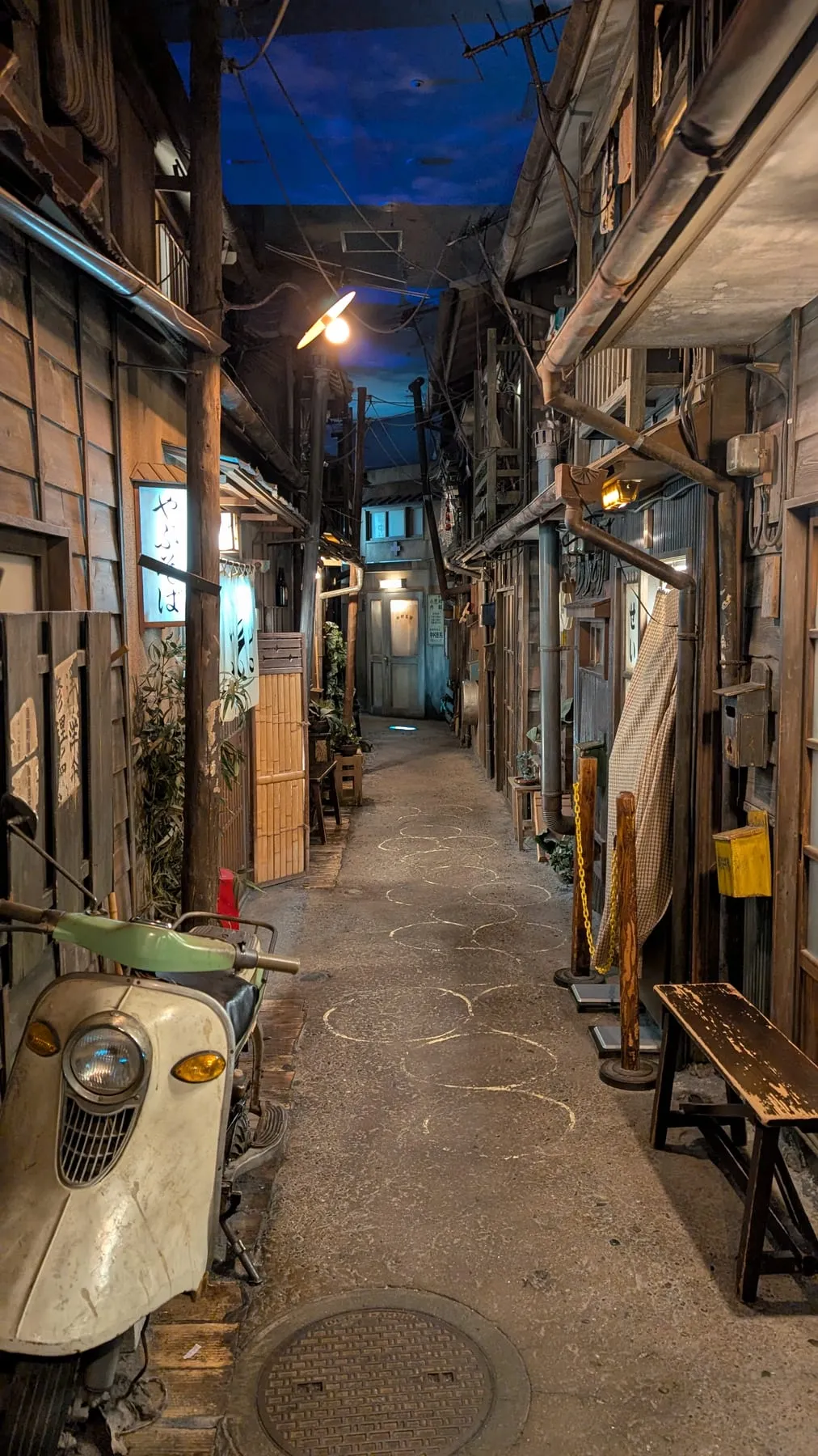 Vicolo ricostruito del vecchio Giappone con un vecchio scooter, dentro il Museo del Ramen